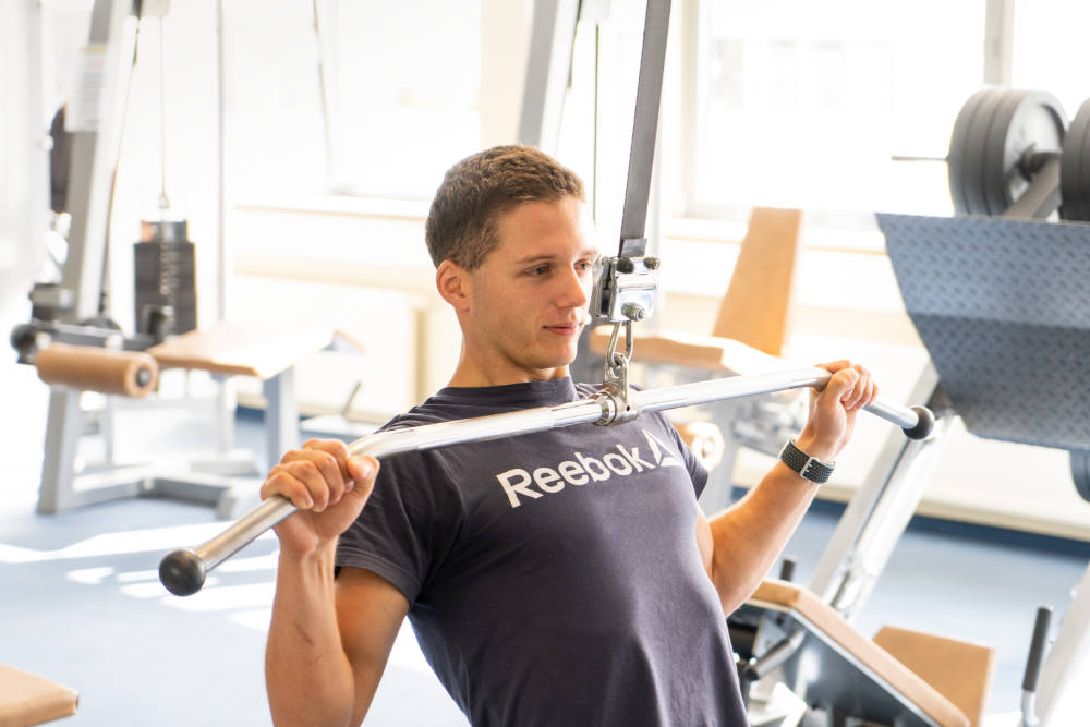 Mitglied trainiert am Latzug-Gerät im Thomas Sport Center